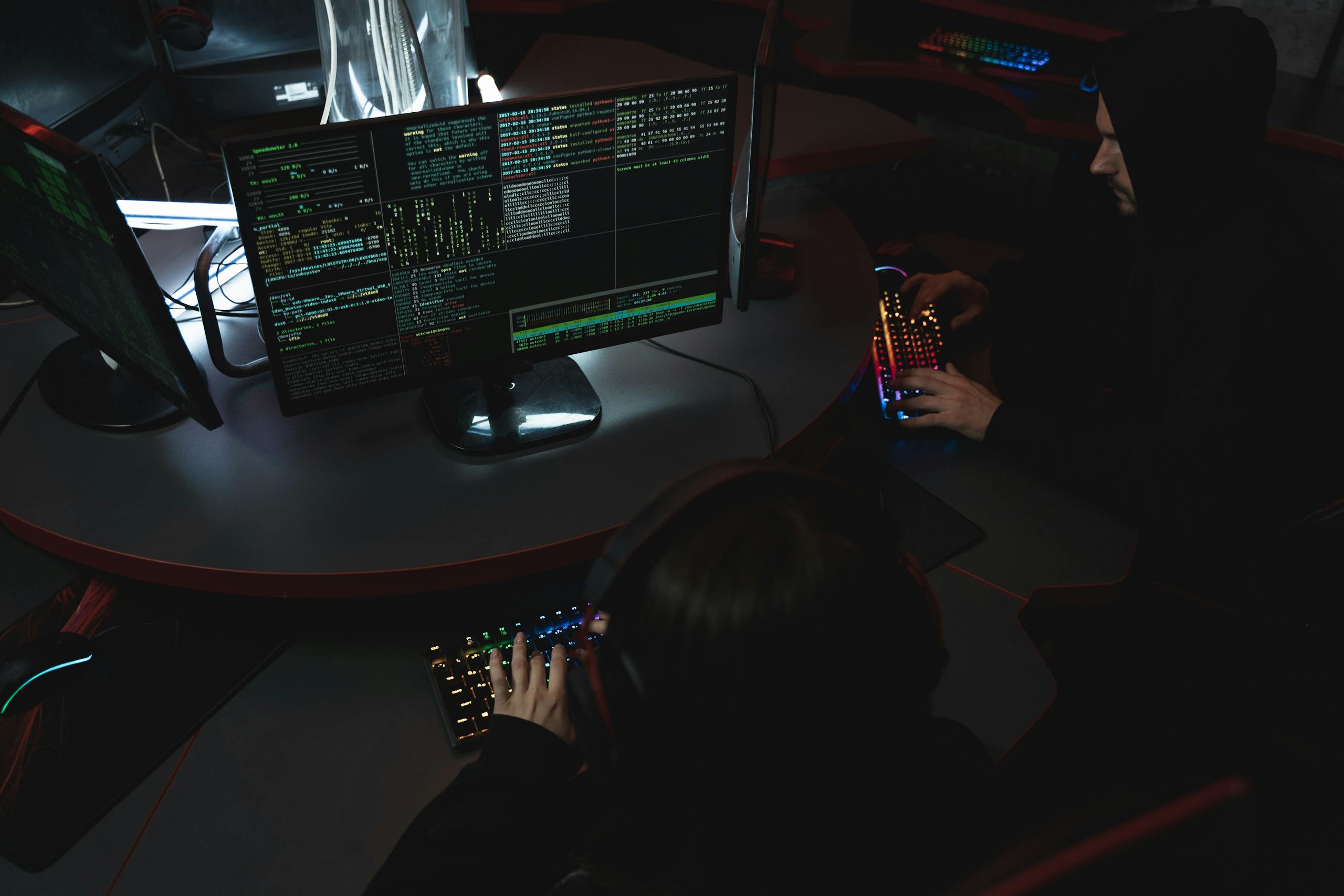 A group of people in a dark room attempting to hack a computer